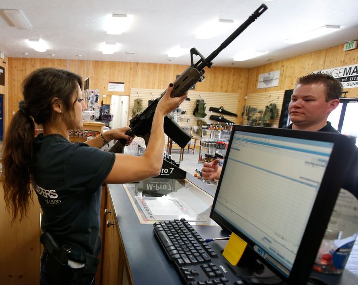Courtney Manwaring, (L) shows an AR-15 semi-automatic gun to David Barker (R) at Action Target on June 17, 2016 in Springville, Utah