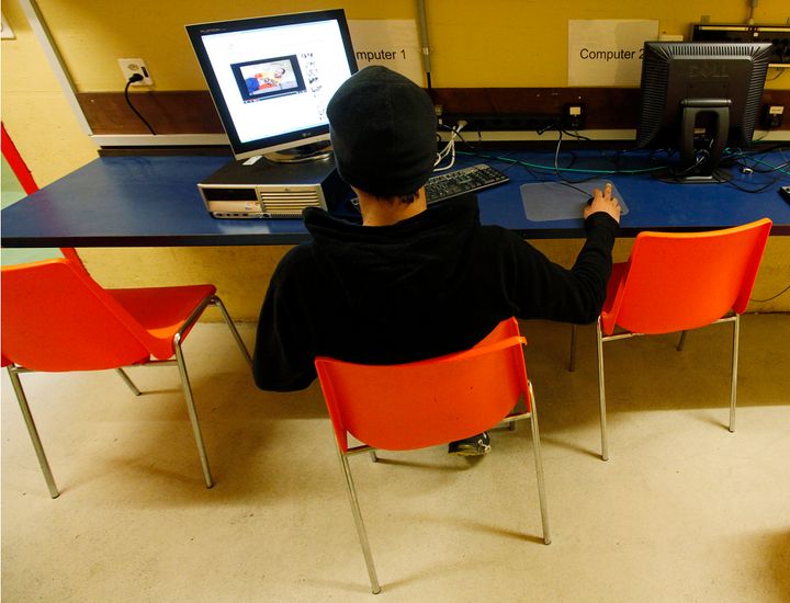 A asylum seeker uses a computer in the internet room of an underground asylum centre for refugees during a tour for media in Biel February 8, 2012. The new asylum centre for refugees opens due to the capacity overload of the regular centres in Switzerland. REUTERS/Pascal Lauener (SWITZERLAND - Tags: POLITICS)