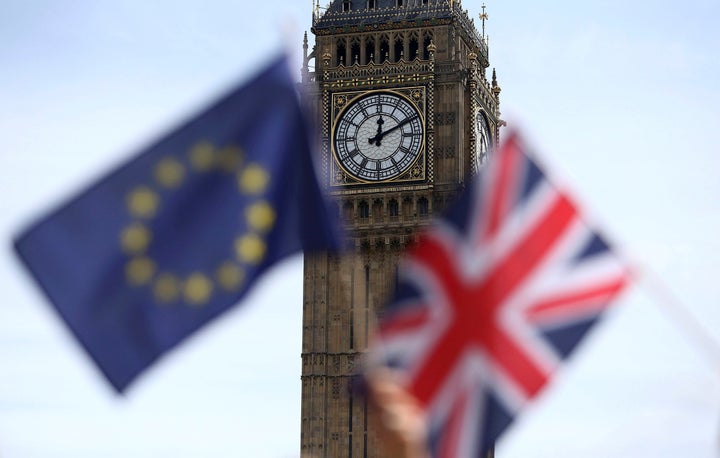 Participants hold a British Union flag and an EU flag during a pro-EU referendum event at Parliament Square in London, Britai