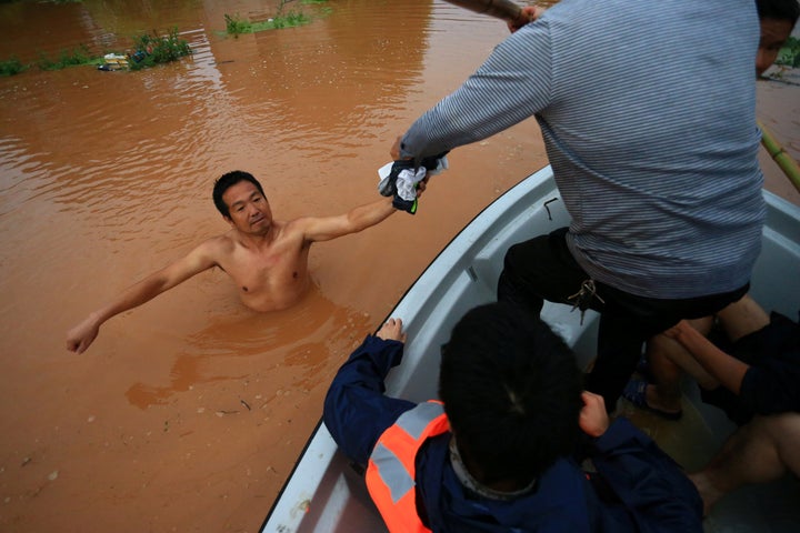 Rescuers save a man wading in flood water after heavy rainfall in Hengyang, Hunan Province, China, on June 15, 2016.