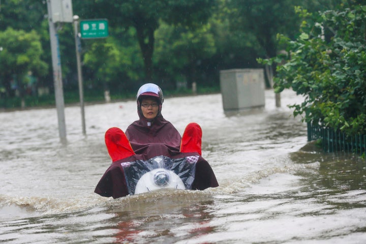 A resident rides a vehicle along a flooded street in Liuzhou, Guangxi Zhuang Autonomous Region, China, on June 14, 2016.