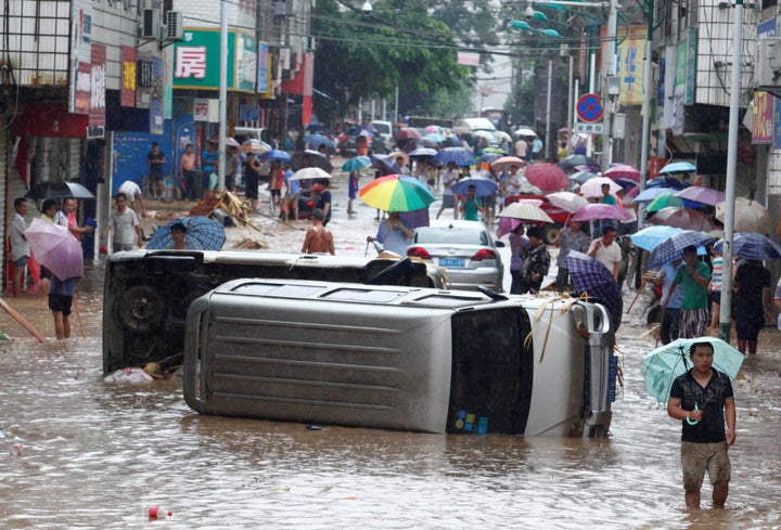 Automobiles are seen overturned on a flooded street in Liuzhou, Guangxi Zhuang Autonomous Region, China, on June 14, 2016.