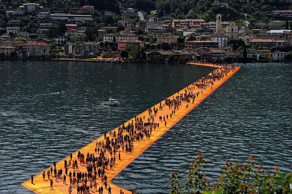 People walk on the installation "The Floating Piers" on Lake Iseo by the Bulgarian artist Christo on June 8, 2016, in Iseo, Italy.