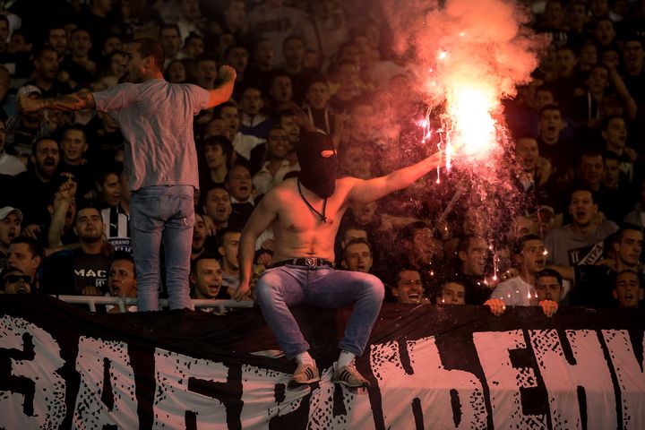 A Partizan Belgrade fan lights a flare during their a match against Red Star Belgrade in Belgrade October 18, 2014