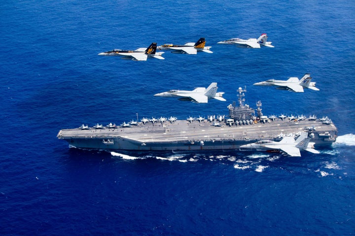 A combined formation of aircraft pass in formation above the Nimitz-class aircraft carrier USS John C. Stennis in the Philipp