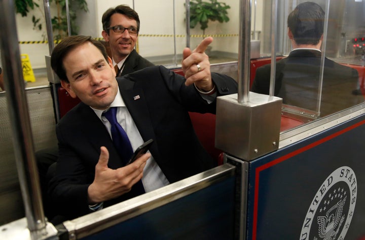 Former Republican presidential candidate Marco Rubio (left) talks to reporters while waiting for the Senate's subway to depart after voting on March 17, 2016.