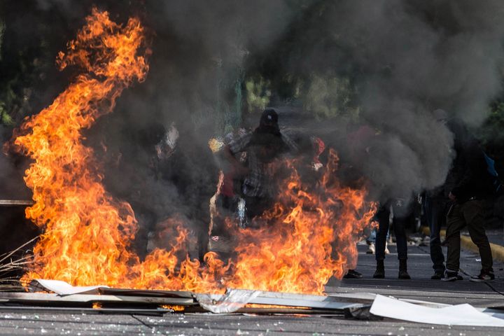Masked protesters block a street in Mexico City on Monday in protest for the recent violent acts in Oaxaca state.