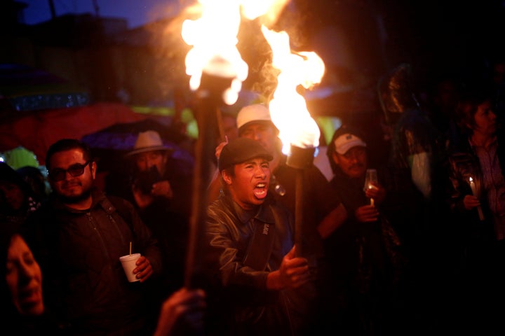 A protester from the National Coordination of Education Workers (CNTE) teachers' union holds a torch as he yells during a mar