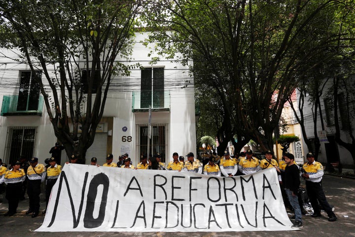 Activists hold a banner that reads "No to education reform" in a demonstration after at least eight people were killed in cla