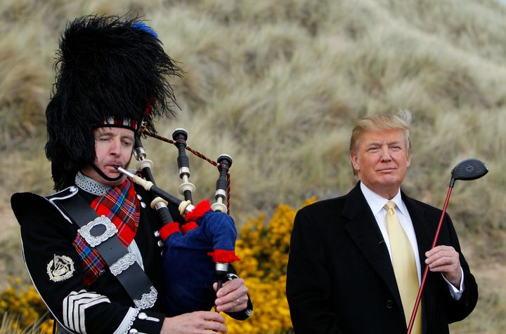 Donald Trump stands next to a bagpiper during a media event on the sand dunes of the Menie estate, the site for Trump's proposed golf resort, near Aberdeen, north east Scotland, May 27, 2010.