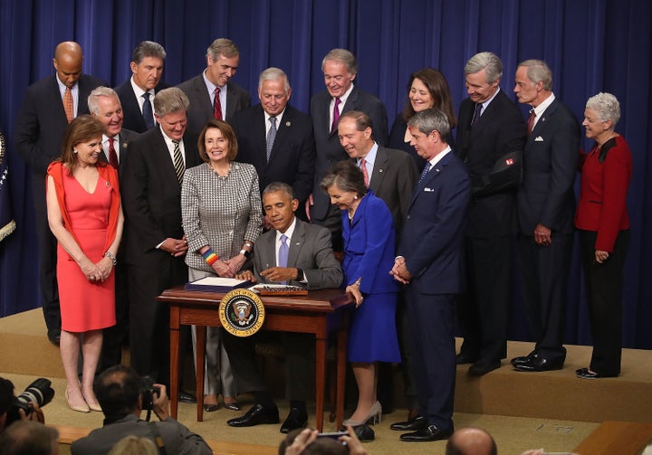 President Barack Obama is flanked by members of Congress as he signs the revised Toxic Substances Control Act, which includes new protections against animal testing.