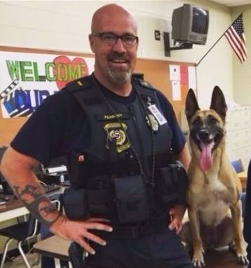 Former Lt. Daniel Peabody, who worked at Cherokee County School District in Georgia, poses with police K9 Inca before her death earlier this month.