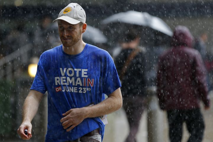 A man wearing a 'Vote Remain' t-shirt walks in the rain in central London.