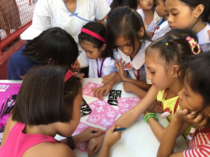 Six-year-old volunteer Anela spent a morning giving glitter tattoos to children in a school feeding program in the Philippines for the charity In-Visible. She enjoyed her experience so much that she's returned to volunteer multiple times since. 