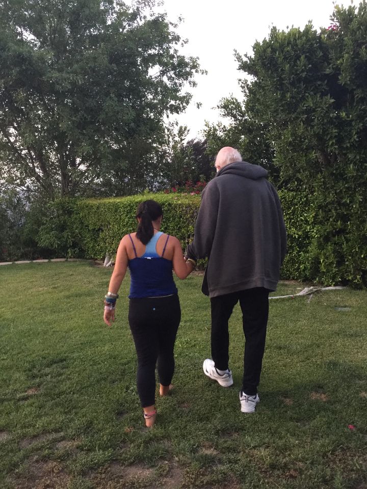 My daughter helps her Dad walk in the yard.