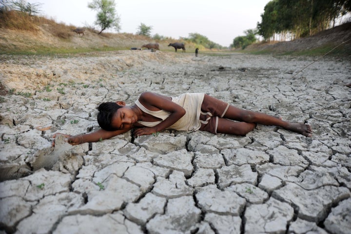 A child lies down on a dry bed of parched mud that is the dried up River Varuna at Phoolpur. Much of India is reeling from a heat wave and severe drought conditions that have decimated crops, killed livestock and left at least 330 million Indians without enough water for their daily needs.