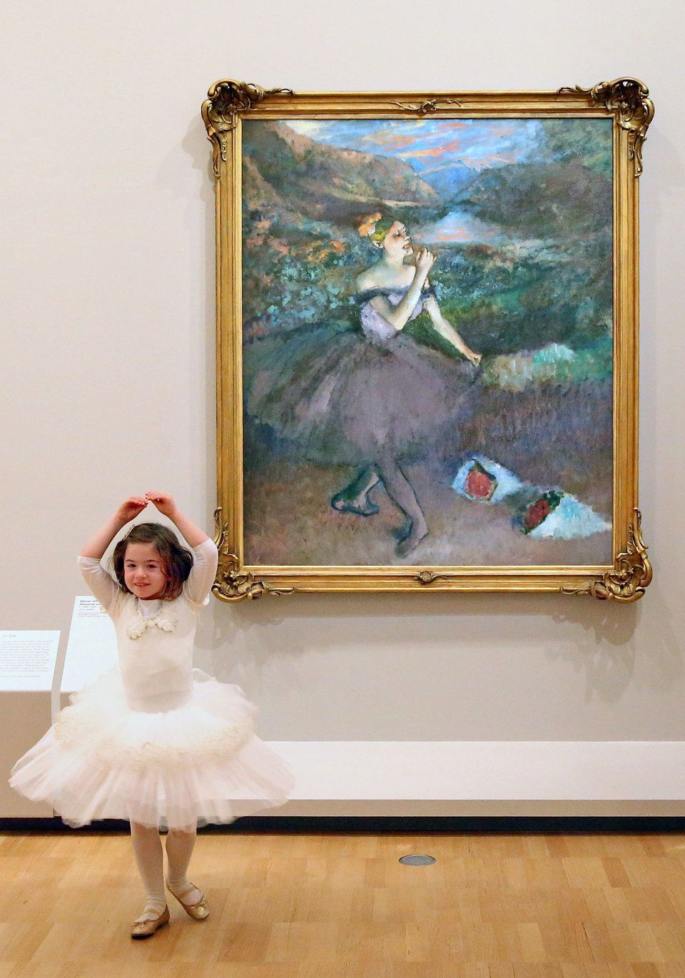Six-year old ballerina Mena Deboil dances next to one of Edgar Degas' iconic ballet dancer paintings "Dancer with Bouquets."