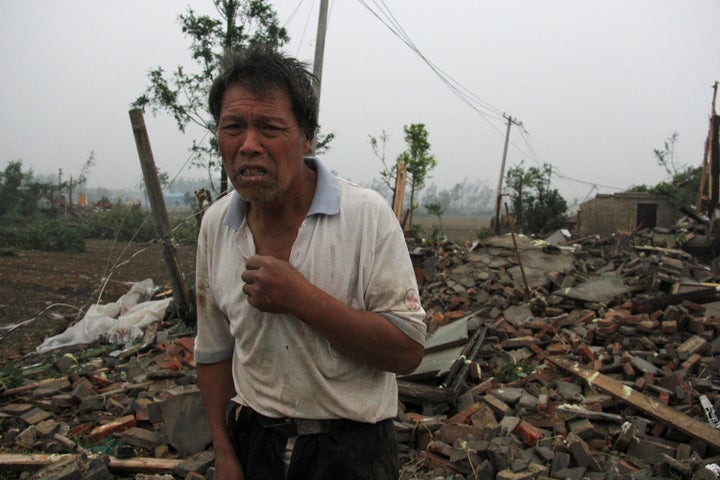 A man stands on debris of his damaged house after a tornado hit Funing county, Yancheng, Jiangsu province, on Thursday.