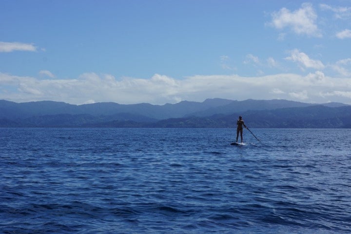 Paddle-boarding off the coast of an island in Fiji. We sailed to Fiji from New Zealand with friends. However, most of our 18 months of travel was done independently.