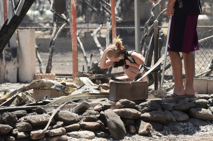 Brittany Thompson cries after finding a deceased dog at a burned down residence after the Erskine Fire burned through South L