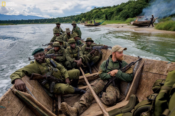 A confiscated boat burns on the beach as rangers, joined by an instructor, try to prevent overfishing on Lake Edward. Fishing