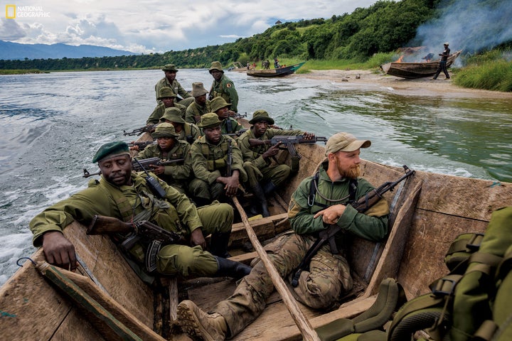 A confiscated boat burns on the beach as rangers, joined by an instructor, try to prevent overfishing on Lake Edward. Fishing, a critical source of local income, is allowed on the lake, but rangers are confronted with thousands of unlicensed boats.