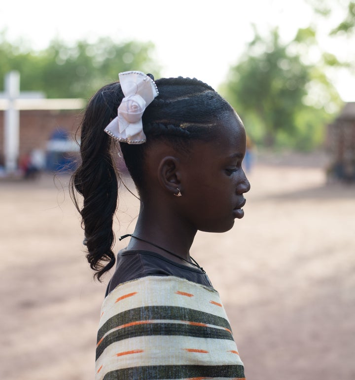 <em>A young girl models a popular, heavily chemical and product-laden hair style often seen during celebrations. </em>