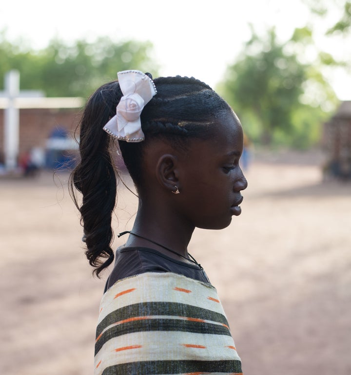 A young girl models a popular, heavily chemical and product-laden hair style often seen during celebrations. 