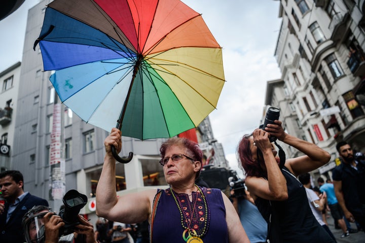 A woman holds a rainbow umbrella during a rally staged by the LGBT community on Istiklal avenue in Istanbul on June 26, 2016.