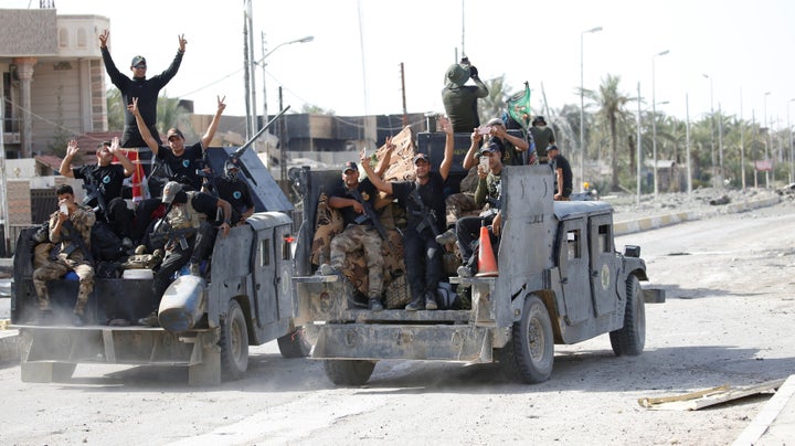 Iraqi counterterrorism forces gesture in Falluja, Iraq, June 26, 2016.