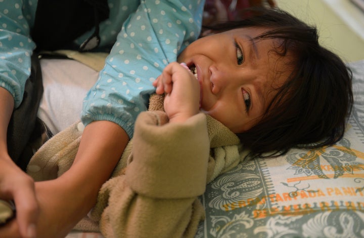 A young Indonesian girl crying as doctors perform her circumcision. Indonesia argues that this form of circumcision is largely symbolic, not harmful and should not be seen as mutilation. The United Nations thinks otherwise.