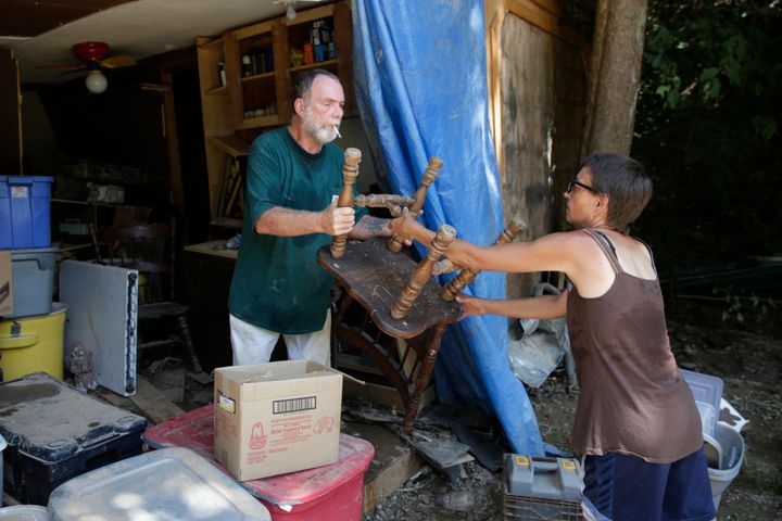 Randy Chapman, 55, passes a chair to his wife, Jamie Chapman, 48, through what was formerly the kitchen wall of their home after flooding in Falling Rock, West Virginia, on Sunday.