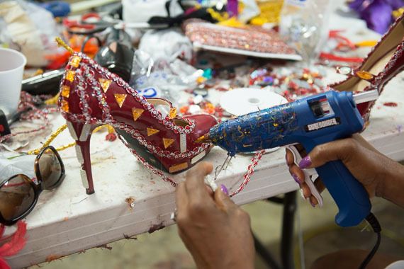 Using a glue gun to put the finishing touches on a Carnival costume at Masqueraders.