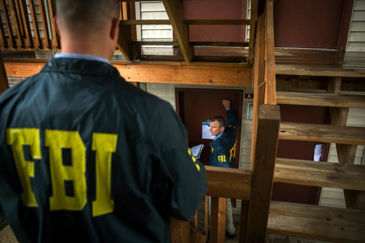 Federal Bureau of Investigation (FBI) agents go door to door to interview residents of the neighborhood where teenager Michael Brown was shot, in Ferguson, Missouri, August 16, 2014.