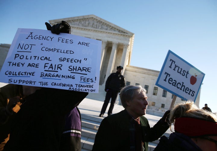 People for and against unions hold up signs in front of the Supreme Court building on Jan. 11, 2016, in Washington, D.C.