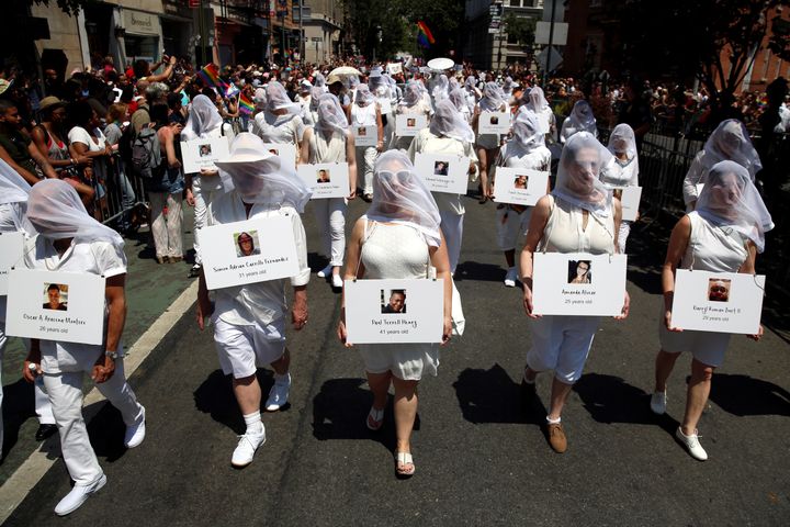 Dressed in white, marchers at the New York City Pride parade on June 26, 2016 carry photos of the people who died in the Pulse nightclub shooting in Orlando. 
