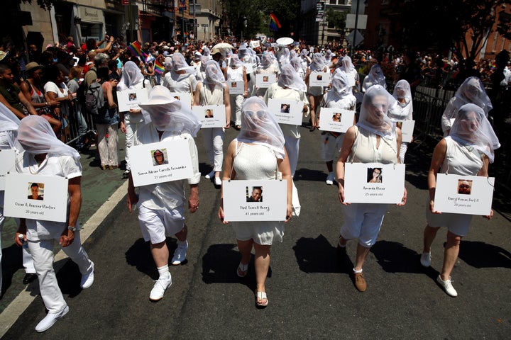 Dressed in white, marchers at the New York City Pride parade on June 26, 2016 carry photos of the people who died i