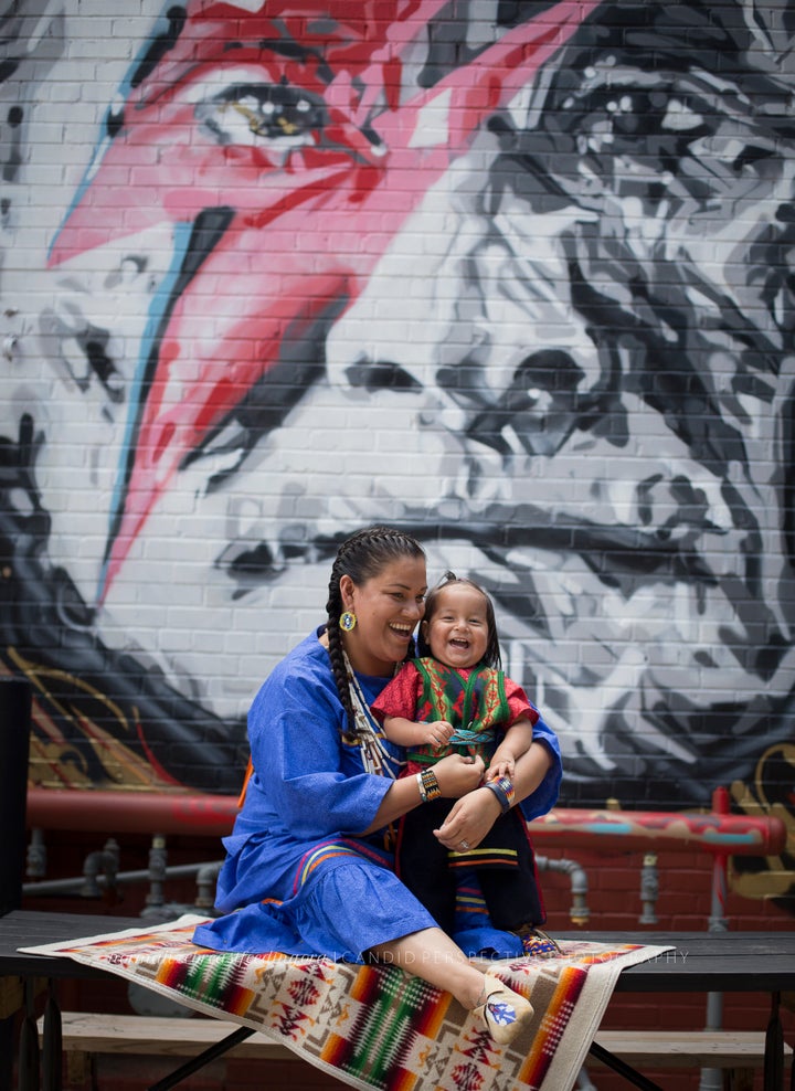 Simmons photographed Enedina Banks in front of a mural of a Native American man.