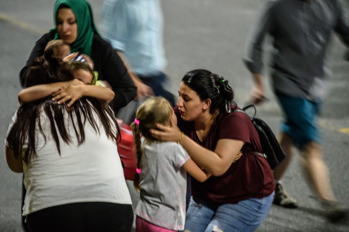 Children and their relatives embrace as they leave Ataturk airport.