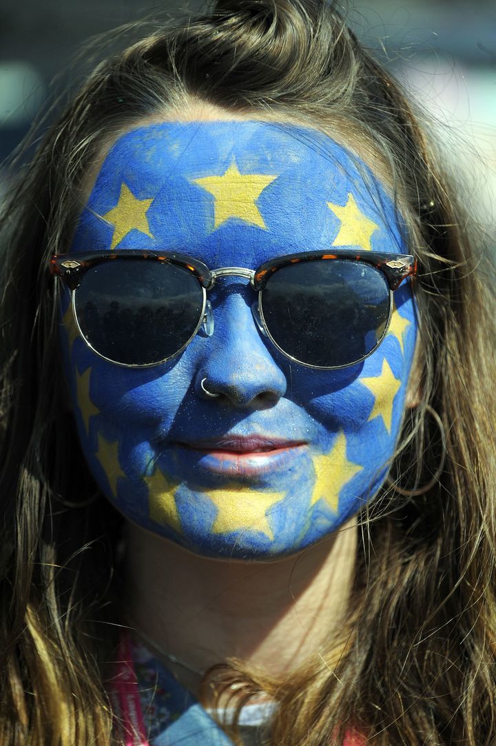 A festival-goer with a European flag painted on her face poses for a photograph on day three of Glastonbury