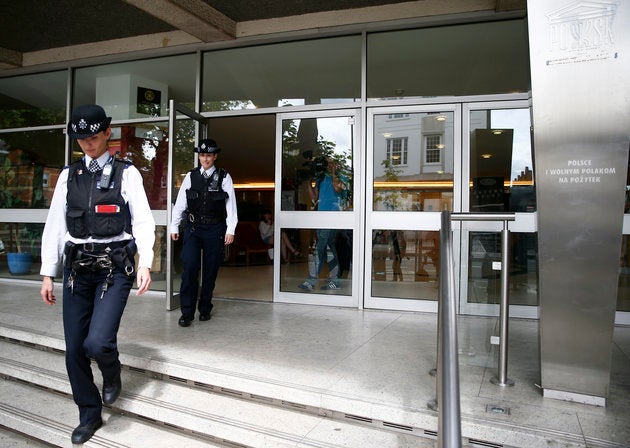 Police officers leave the Polish Social and Cultural Association after graffiti was daubed on the side of the building