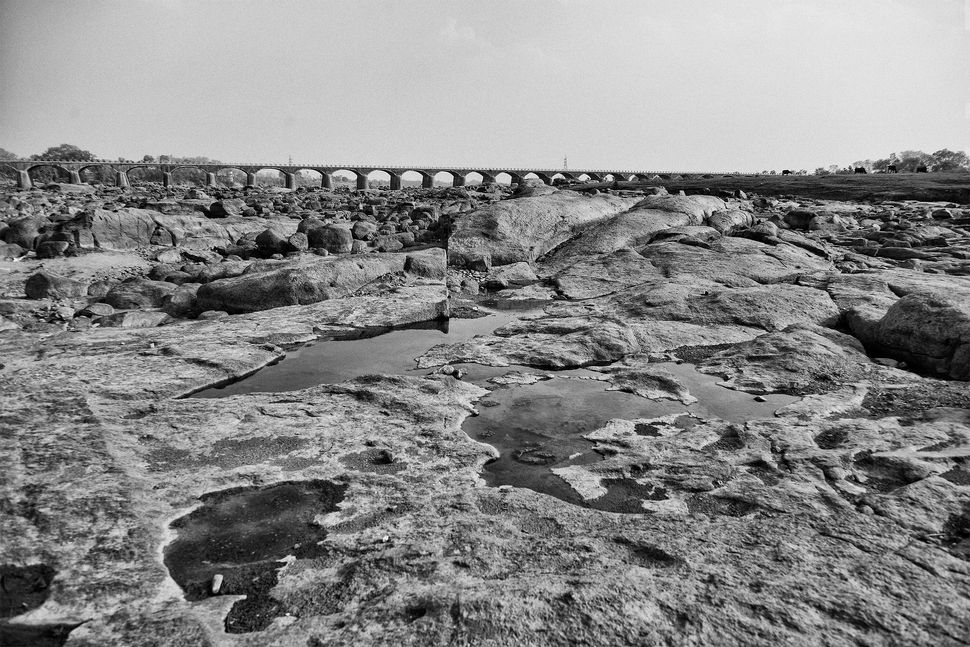 The Dhasan River once flowed along the edge of Garroli. Now all that's left is a vast rocky bed and a few pools of water refl