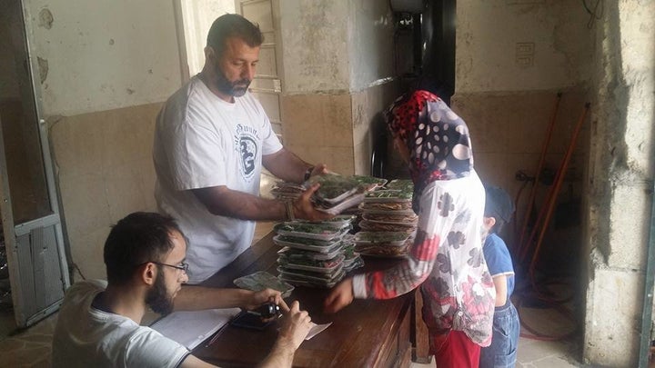 Adham handed out meals to families trapped in Aleppo during Ramadan earlier this month.