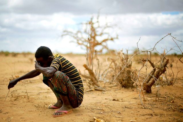 Muhumed Surow grieves following the burial of his 12-month-old daughter Liin Muhumed Surowlays at UNHCR's Ifo Extension camp