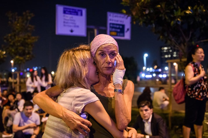Passengers embrace outside Istanbul Ataturk Airport on June 28 after three suicide bombers attacked outside of the
