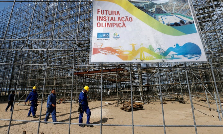 Workers are pictured at the construction site of the beach volleyball venue for 2016 Rio Olympics on Copacabana beach.