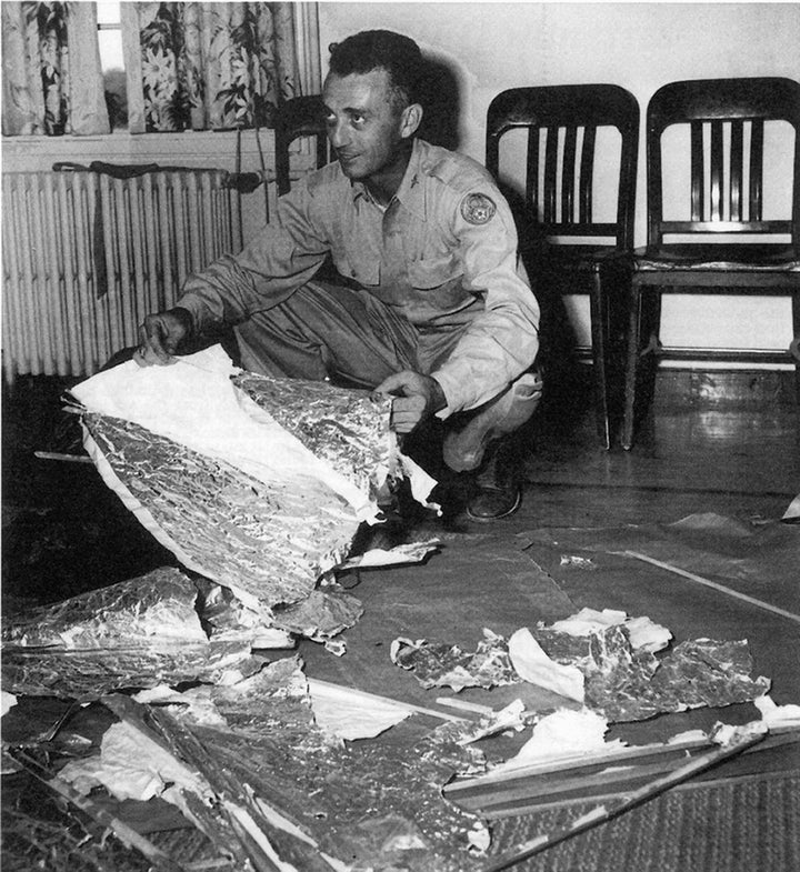 In July 1947, Maj. Jesse Marcel of the Roswell Army Air Field in New Mexico shows members of the press alleged pieces of a we