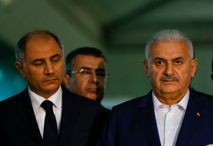 Turkey's Prime Minister Binali Yildirim (R) speaks to the press next to the Interior Miinister Efkan Ala at the Ataturk airport in Istanbul, Turkey, following a multiple suicide bombing, June 29, 2016.