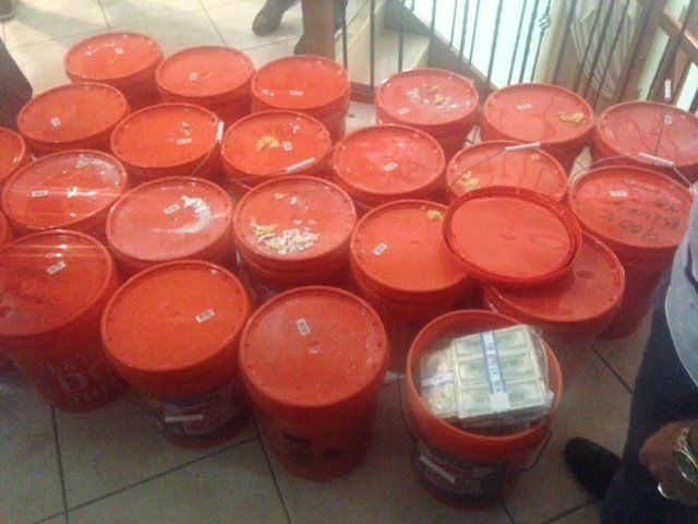 The bulk of the money seized allegedly came out of these 5-gallon containers that were found hidden behind a wall.