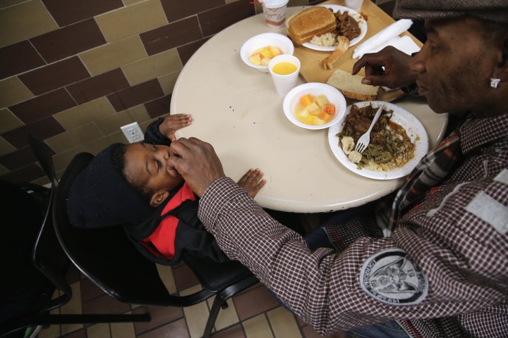 A father feeds his son dinner at a soup kitchen run by the Food Bank For New York City. The food bank distributes dry, canned and fresh food to needy residents and works with community based member programs to provide some 400,000 free meals per day throughout the city.